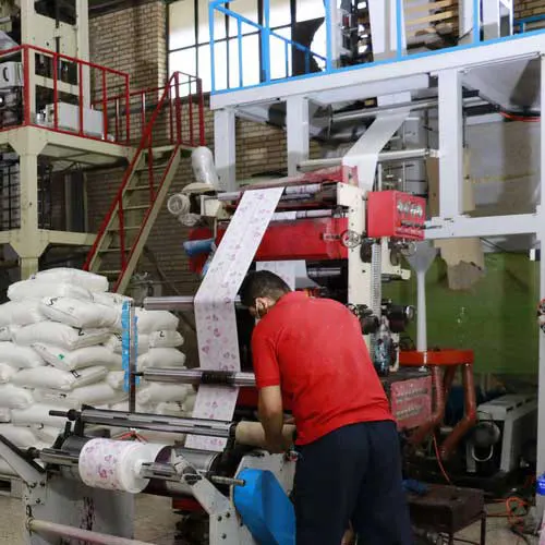 کارگر در حال کار با دستگاه تولید سفره یکبار مصرف